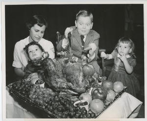 Young clients carving turkey at Thanksgiving party