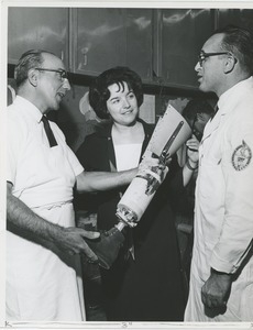 Two technicians and a woman discuss a prosthetic leg