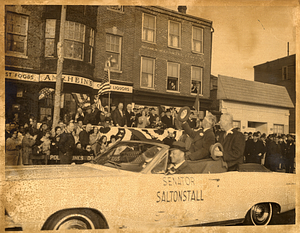 Massachusetts Senator Leverett A. Saltonstall (waving hat) riding in car with three unidentified men during parade