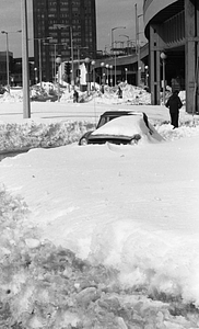 Pedestrians and cars among snowdrifts near highway