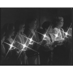 Line of children holding candles during a performance