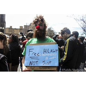Man with "Free Hugs! Not Just For Runners!" sign