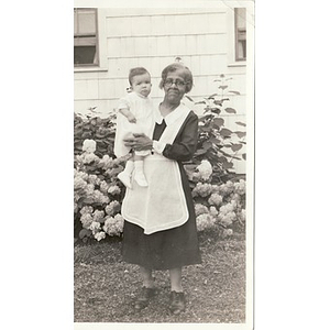 A housekeeper holds a young infant