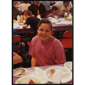 A girl seated at a table smiles for the camera at a Boys & Girls Club Awards Night