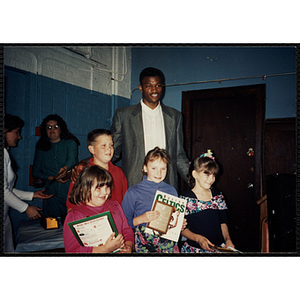 Former Boston Celtic Reggie Lewis posing for a group picture with a boy and three girls at a Kiwanis Awards Night