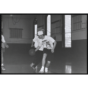 Several men playing a basketball game during the Boys and Girls Clubs of Boston 100th Anniversary Celebration event at the Charlestown Boys and Girls Club gymnasium