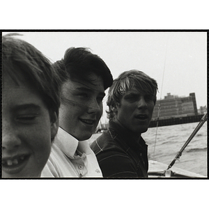 A Group of youth smiling while on a sailboat