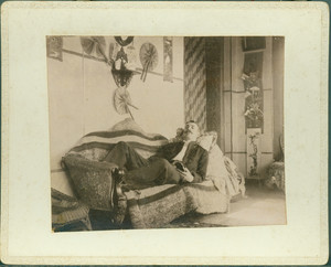 Unidentified man reclining on sofa with a book, Piazza, Castle Tucker, Wiscasset, Maine, undated