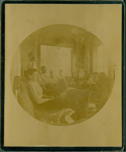 Informal group portrait of the Tucker family seated indoors, unknown location