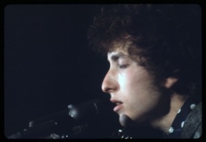 Bob Dylan performing on stage, close-up at the microphone