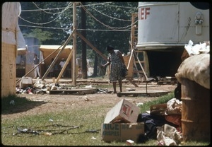 Woman walking among the waste and tents at the Resurrection City encampment