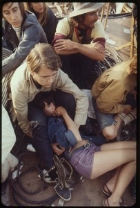 Man propping up a woman on the ground during the Woodstock Festival