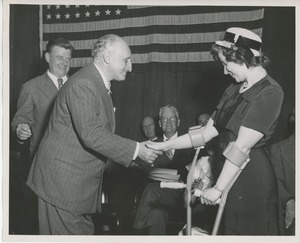 Dr. Gustav Bychowski shaking hands with client Marie Terrett on stage at Institute Day