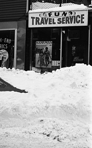 Car buried in snow in front of Fun Travel Service on Parameter Street