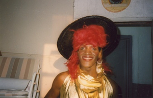 A Photograph of Marsha P. Johnson Wearing a Black, Red, and Gold Outfit