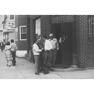 Mayor Raymond Flynn stands with three men outside a building near Tremont and Wigglesworth Streets