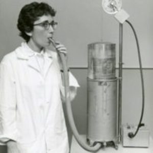 Eleanor Gatz breathing into a device to test the effect of an irritant gas on the lungs