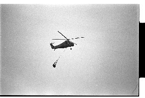 British Army Wessex helicopter flying, carrying munitions in a net underneath