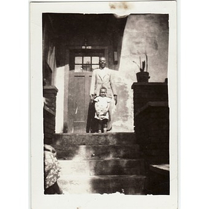 Man and child stand on front steps