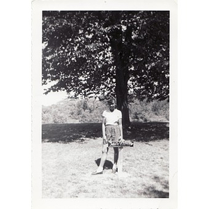 A girl poses with a sign pointing to the picnic grounds at Breezy Meadows Camp