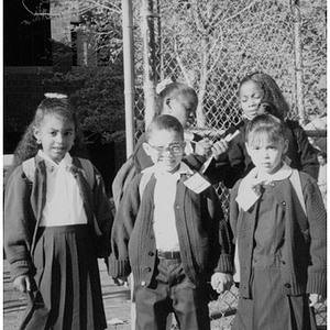 Five schoolchildren in their school uniforms.
