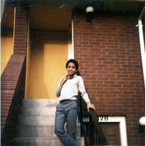 Boy standing on the front steps of a Villa Victoria row house.