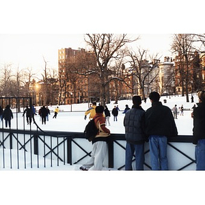 Villa Victoria residents skating on Frog Pond with Boston's Beacon Street as a backdrop.