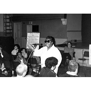 Woman addresses fellow community members at a community meeting.