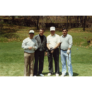 A four-man golf team posing on the golf course at a Boys and Girls Club Golf Tournament