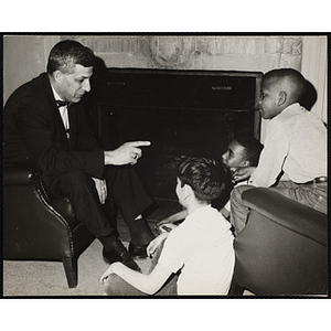 John G. Magistrelli, on the left, enjoys a fire side chat with three boys