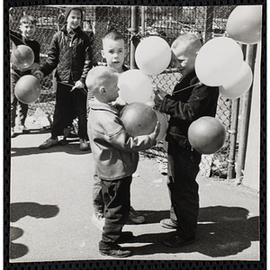 Boys stand with ballons during a ballon raising at a carnival