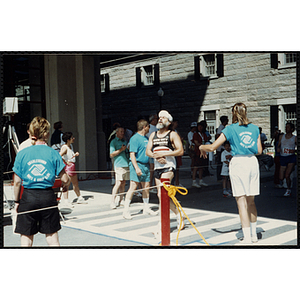 A man runs across the finish line of the Battle of Bunker Hill Road Race