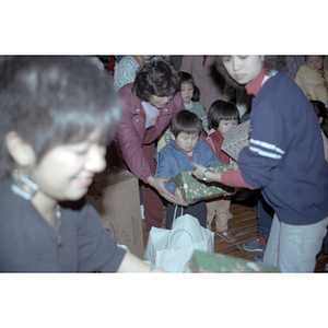 Children receiving gifts at a Chinese Progressive Association anniversary event