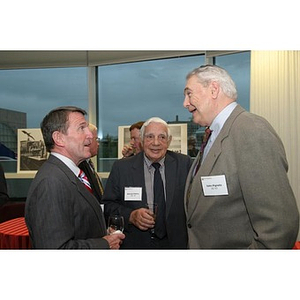 Three men converse at the Veterans Memorial dinner