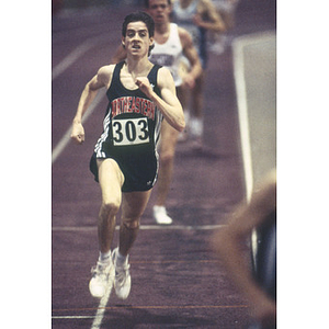 A Northeastern student, number 303, from the men's indoor track and field team competing in the Greater Boston Championships at Harvard