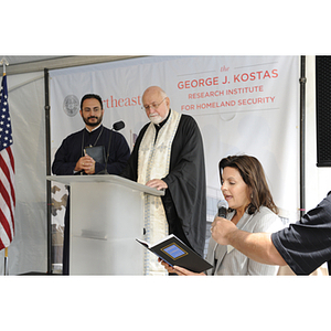 Cynthia Kostas reads from a book of Sacraments and Services during the groundbreaking ceremony