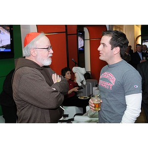 Cardinal O'Malley conversing with a young man at the Beanpot Reception