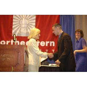 Jorge Sanchez, right, and Karen T. Rigg shaking hands at the Student Activities Banquet