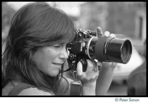 Lynn Goldsmith taking a photograph using her Nikon telephoto lens
