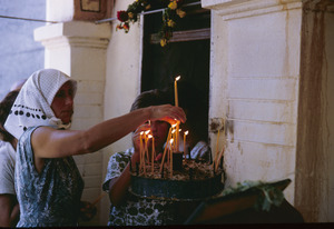 Woman lighting monastery candles