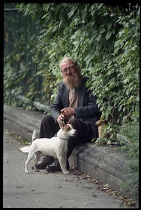 Man and his dog seated by an iron fence on a Dublin street