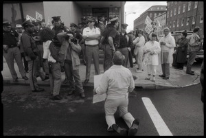 Pro-life protester on his knees, facing a line of police in front of the Providence Planned Parenthood clinic