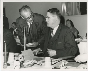 Dr. Louis Stevens speaking with unidentified man at Thanksgiving celebration