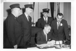 Bill signing with Boston firemen and Governor Foster Furcolo, 11 April 1960