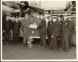 The pilot who flew the stone over from England presents it to members of the Reading, MA Fire Department