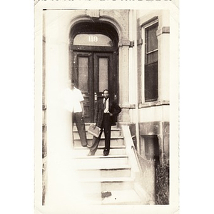 Two men pose on a building's front steps