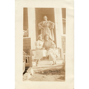 Three women pose on the steps of a gazeebo