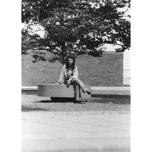 A young Hispanic women seated on a bench, outside, at a La Alianza retreat, at an unidentified campus, [Aug.?] 1978