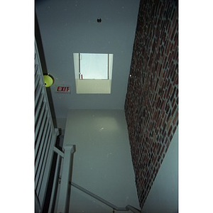 Staircase, exposed brick wall, and skylight in Residence Betances.
