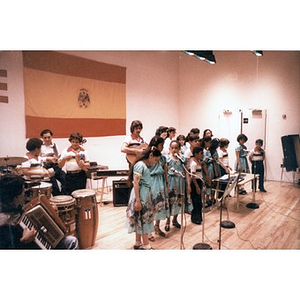 Children singing, accompanied by other children and adults playing traditional Puerto Rican musical instruments.